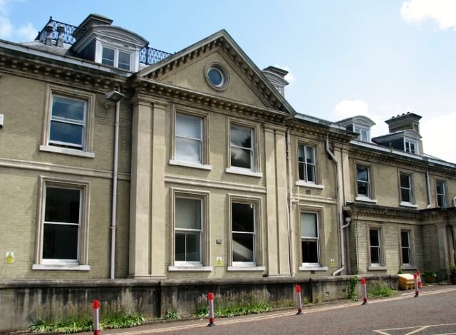 Archive view of Carrow House, showing its pale facade, tall windows and central pediment