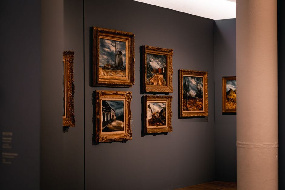 Illustrative stock photo of framed paintings displayed along a gallery wall