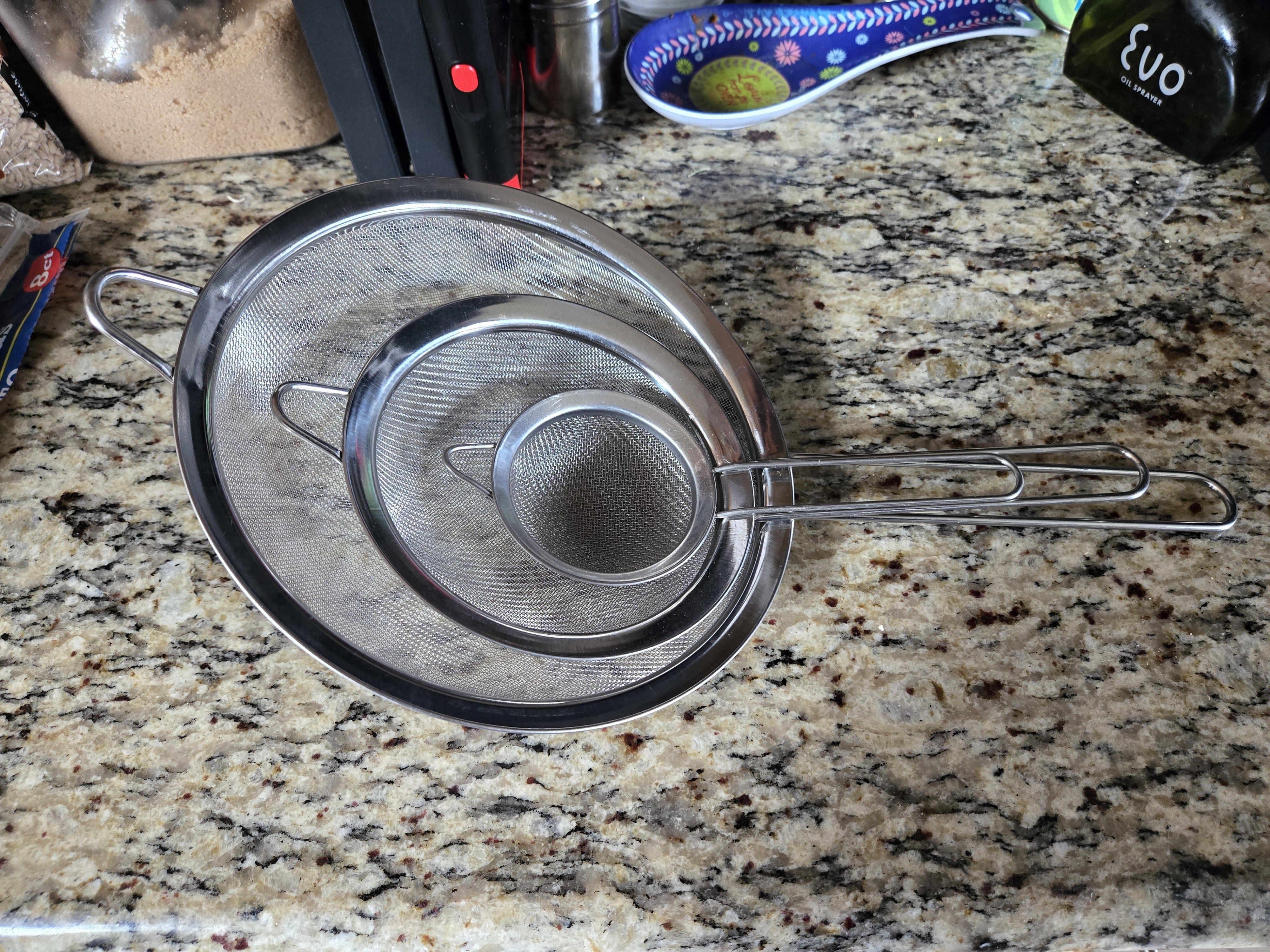 My three stainless steel fine-mesh strainers arranged together on the kitchen counter