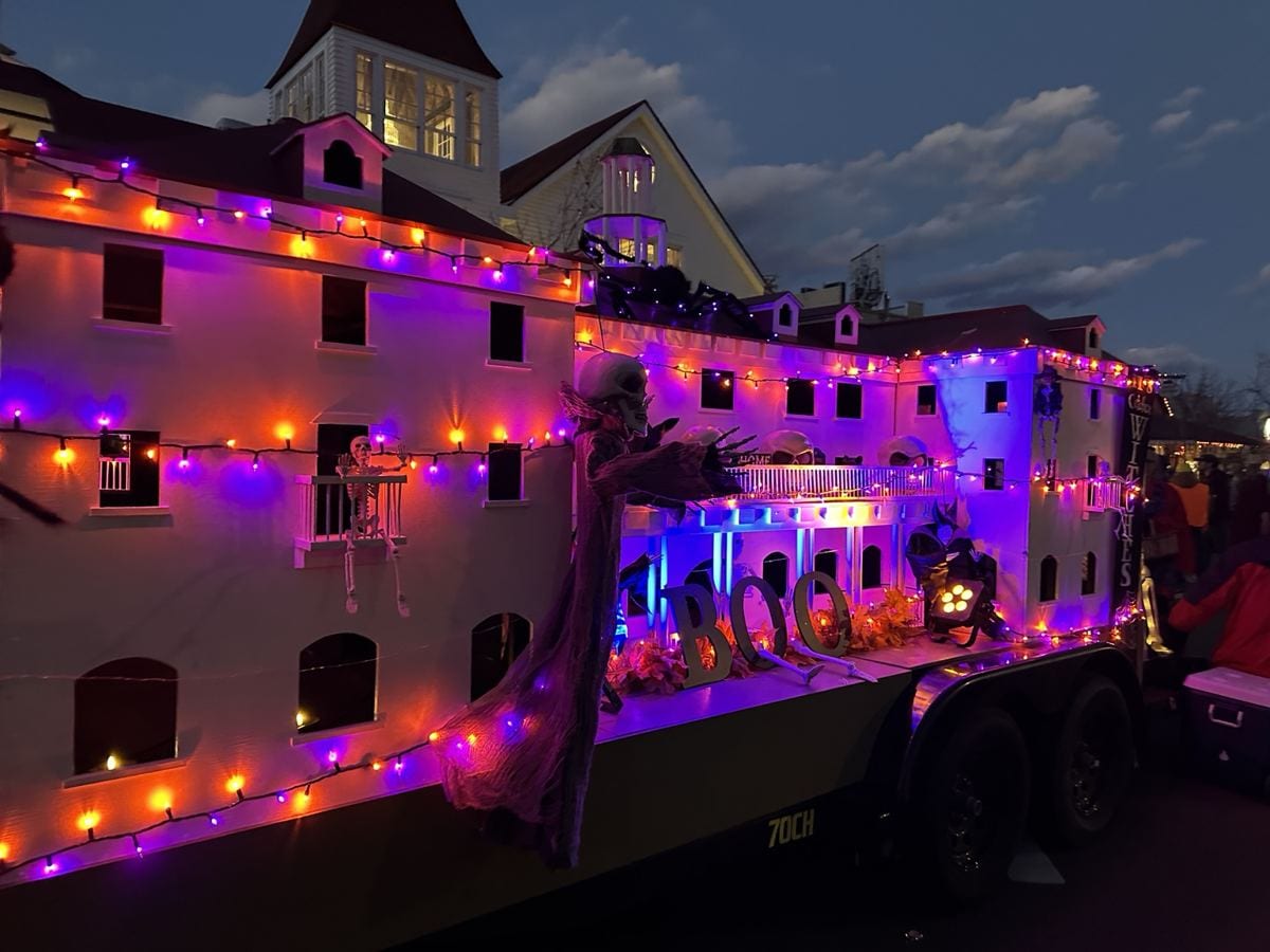 A miniature haunted-building display decorated with skeletons and purple and orange lights in downtown Estes Park.