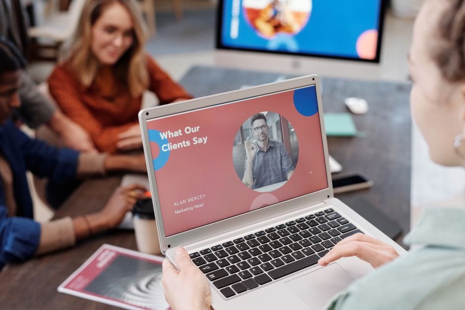 Colleagues discussing a laptop presentation in an office, illustrative stock photograph