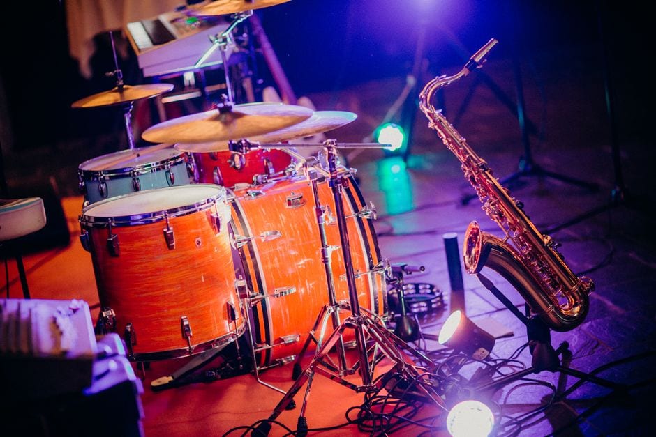 Illustrative stock photo of drums and a saxophone on a lit stage, not the CU Jazz Festival or Kyle Swan Quartet.