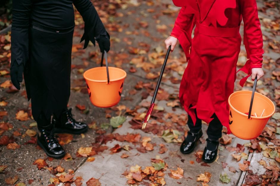 Illustrative stock photo of children carrying small orange Halloween buckets